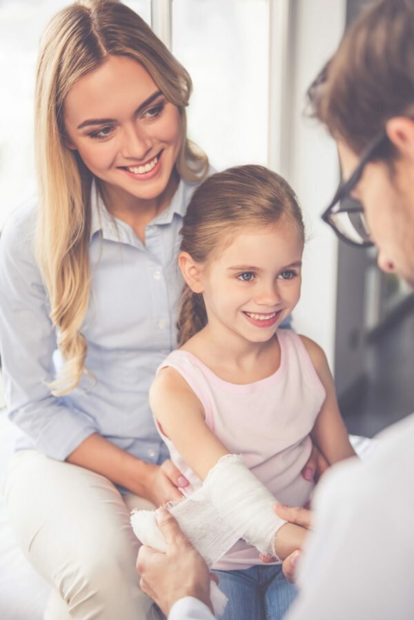 Mother holding daughter at clinic